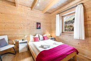a bedroom with a bed in a wooden room at Alpen Chalets Ausseerland - Sauna & BBQ in Bad Mitterndorf