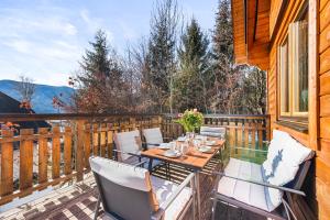 a patio with a table and chairs on a deck at Alpen Chalets Ausseerland - Sauna & BBQ in Bad Mitterndorf