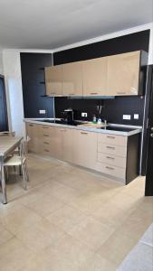 a kitchen with white cabinets and a table and a dining room at Apart-Hotel Argo in Lozenets +1 photo