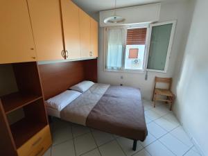 a small bedroom with a bed and a window at Residence Sporting in Rosolina Mare +19 photos