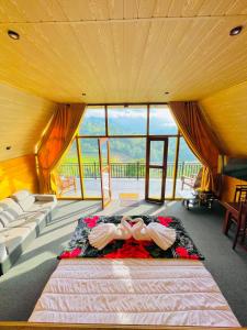 a bedroom with a bed with shoes on it at Paddy Breeze Cabana Ella in Ella