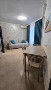 a living room with a table and chairs and a couch at Apart-Hotel Argo in Lozenets
