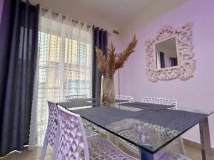 a dining room with a glass table and a mirror at Wedgewood - The XL Suite in Sliema