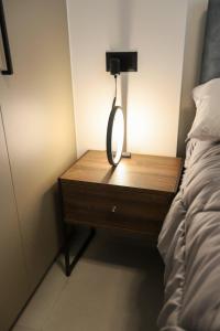 a lamp on a wooden table next to a bed at RiposoRooms in Nafpaktos