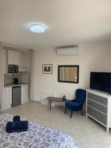 a bedroom with a bed and a table and a blue chair at Villa Sole Flats in Saint Paul de Vence