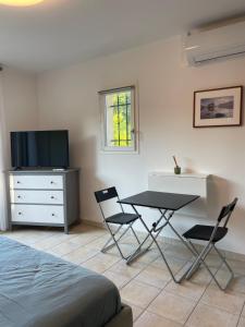 a bedroom with a table and chairs and a television at Villa Sole Flats in Saint Paul de Vence