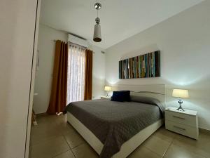 a bedroom with a bed and a painting on the wall at Wedgewood - The XL Suite in Sliema