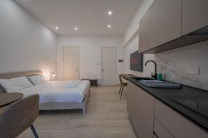 a bedroom with a bed and a kitchen with a desk at Urban Vibe 3 in Kirkop