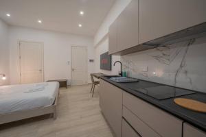 a bedroom with a bed and a kitchen with a counter at Urban Vibe 3 in Kirkop