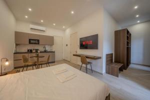 a bedroom with a large bed and a kitchen at Urban Vibe 1 in Kirkop +8 photos