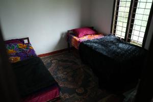 a small room with two beds and a window at Fogveilhomestay in Idukki