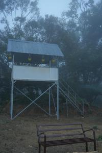 a bench next to a lifeguard station with a sign at Fogveilhomestay in Idukki