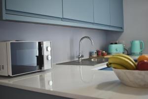a kitchen with a bowl of fruit and a microwave at Sunday Cottage in St. Just