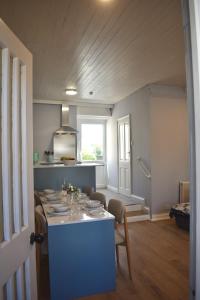 a dining room with a table with chairs and a kitchen at Sunday Cottage in St. Just