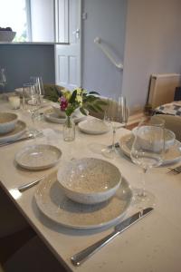a table with plates and wine glasses on it at Sunday Cottage in St. Just +35 photos
