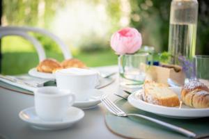 a table with plates of coffee and pastries on it at Casale della Vittoria - Guest House in Taranto