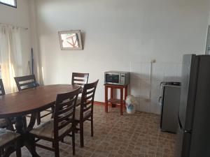 a dining room with a table and a refrigerator at Casuarinas Del Mar Hospedaje Chalet 3 habitaciones in Canoas