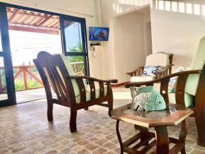 a room with rocking chairs and a room with a window at Casuarinas Del Mar Hospedaje Chalet 3 habitaciones in Canoas