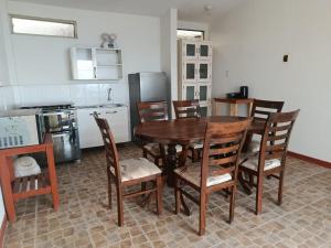 a kitchen with a wooden table and chairs in a room at Casuarinas Del Mar Hospedaje Chalet 3 habitaciones in Canoas
