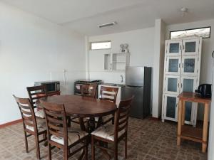 a kitchen with a table and chairs and a refrigerator at Casuarinas Del Mar Hospedaje Chalet 3 habitaciones in Canoas +21 photos