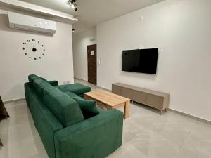a living room with a green couch and a tv at 3-Bedroom with Jacuzzi & Private Terrace in Is-Swieqi