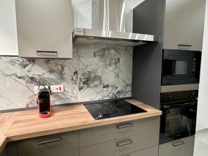 a kitchen with a counter with a stove and a microwave at 3-Bedroom with Jacuzzi & Private Terrace in Is-Swieqi