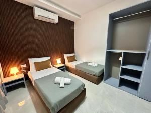 a small bedroom with two beds and a window at 3-Bedroom with Jacuzzi & Private Terrace in Is-Swieqi +16 photos