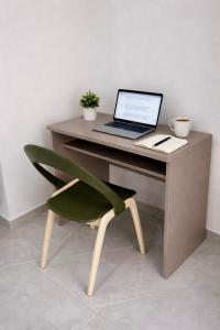 a laptop computer sitting on a desk with a chair at 3-Bedroom with Jacuzzi & Private Terrace in Is-Swieqi