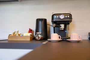 a coffee maker sitting on top of a counter with cups at RiposoRooms in Nafpaktos +139 photos