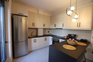 a kitchen with white cabinets and a black counter top at RiposoRooms in Nafpaktos