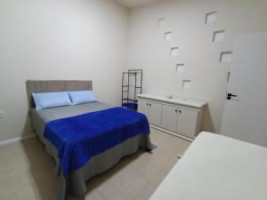 a bedroom with a bed with a blue blanket at Casa MonteFlor - Refúgio onde a vida desacelera com gentileza in Governador Celso Ramos