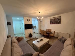 a living room with a couch and a table at Cozy Apartment in Prishtinë