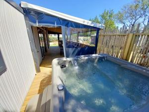a hot tub in a backyard with a blue canopy at ZEcamping 3 animaux acceptés club enfant piscine couverte in Prigny