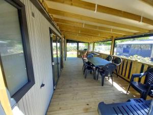 a porch with a table and chairs on it at ZEcamping 3 animaux acceptés club enfant piscine couverte in Prigny