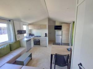 a living room with a couch and a kitchen at ZEcamping 3 animaux acceptés club enfant piscine couverte in Prigny