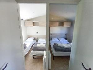 a room with two beds and a mirror at ZEcamping 3 animaux acceptés club enfant piscine couverte in Prigny +49 photos