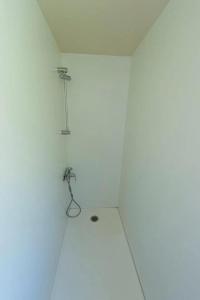a white room with a shower in the corner at ZEcamping 4 étoiles avec restaurant et animations Alpe dHuez in Le Bourg-dʼOisans