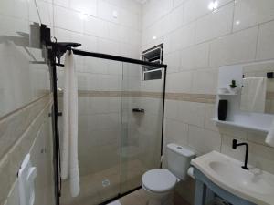 a bathroom with a shower and a toilet and a sink at Casa MonteFlor - Refúgio onde a vida desacelera com gentileza in Governador Celso Ramos +34 photos