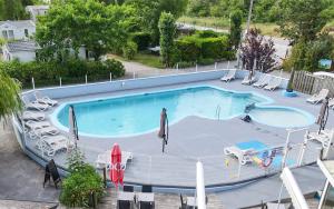 an overhead view of a swimming pool with chairs and umbrellas at Camping les 3 Sablières in Saint-Firmin
