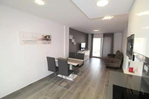 a living room with a dining room table and chairs at Cozy Apartment in Vinaròs with Shared Pool in Vinarós