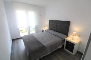 a bedroom with a large bed and a window at Cozy Apartment in Vinaròs with Shared Pool in Vinarós