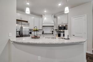 a kitchen with white cabinets and a large kitchen island at Where Comfort Meets Convenience in Burleson