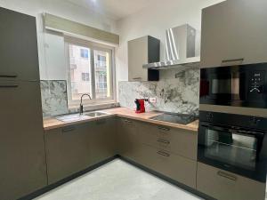 a kitchen with a sink and a stove at Large 3-Bedroom with Jacuzzi near St Julians in Is-Swieqi