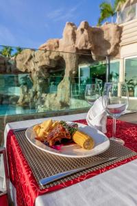 a plate of food on a table with wine glasses at Anfi del Mar Tauro Golf 1 Emerald Club in Mogán