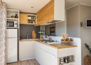 a kitchen with white cabinets and a stove top oven at Camping 4 etoiles - Espace aquatique - 500m plage - ccagefg in Portiragnes