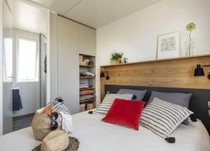 a bedroom with a large white bed with pillows at Camping 4 etoiles - Espace aquatique - 500m plage - ccagefg in Portiragnes