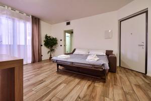 ein Schlafzimmer mit einem Bett und einem Holzboden in der Unterkunft Casa Pintea in Legnano