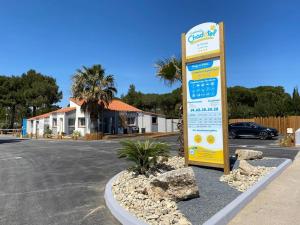 a sign in a parking lot next to a street at ZEcamping 4 étoiles avec chiens acceptés piscine chauffée à 1km de la plage in Torreilles