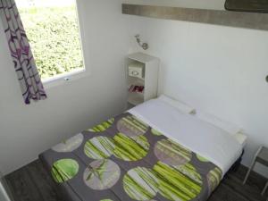 a bed in a small room with a window at ZEcamping 3 étoiles piscine chauffée club enfant dog friendly in Ploemeur