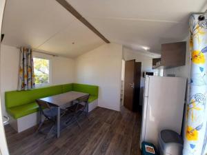 a small kitchen with a table and a refrigerator at ZEcamping 3 étoiles piscine chauffée club enfant dog friendly in Ploemeur